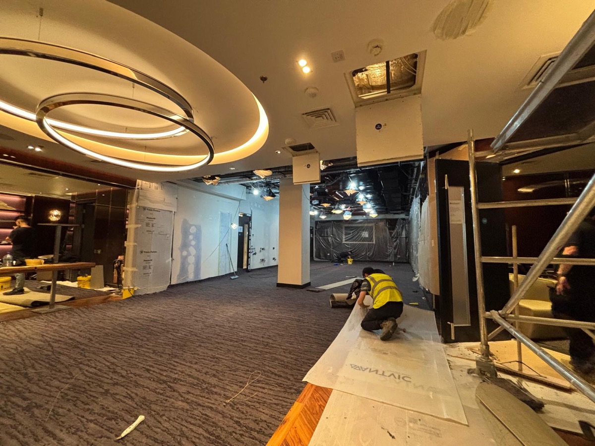 Hospitality fit-out with circular feature light and carpet installation